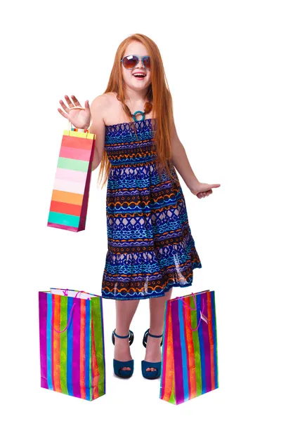 Glad mode liten rödhårig flicka med kassar och påsar. — Stockfoto