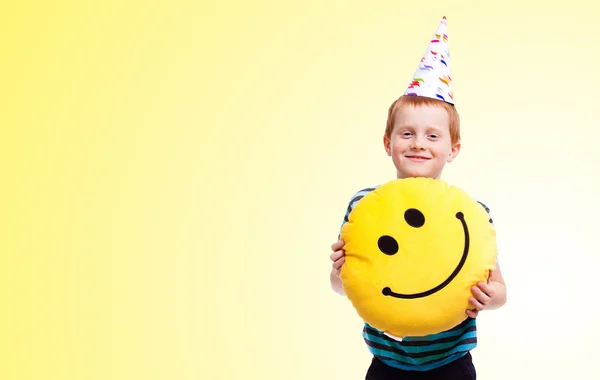 Liten pojke i födelsedag cap på gul bakgrund — Stockfoto