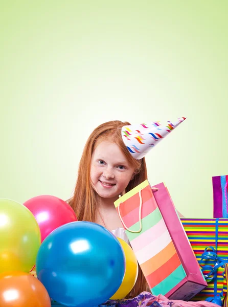Festa feliz menina ruiva com balões e caixa de presente em ba verde — Fotografia de Stock