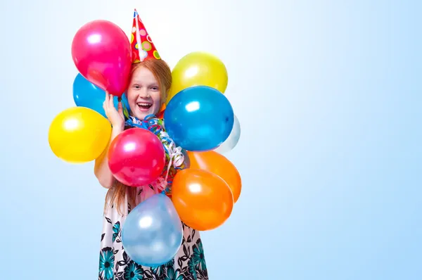 Niña feliz con globos sobre fondo azul Imágenes de stock libres de derechos