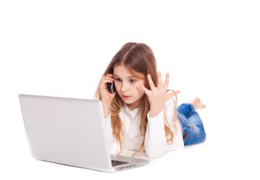 bir dizüstü bilgisayar ve mobil fon çalışma katta yatan küçük kız