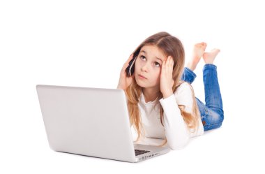 bir dizüstü bilgisayar ve mobil fon çalışma katta yatan küçük kız