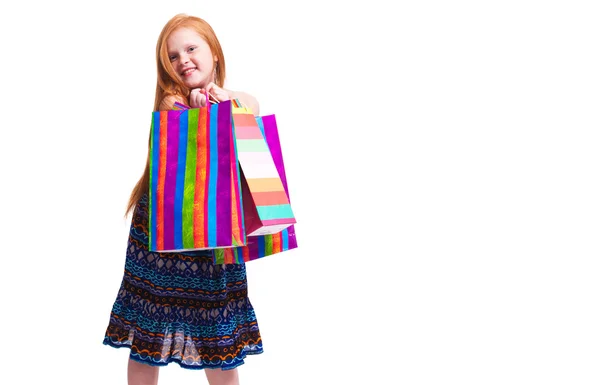 Compras infantiles. Moda feliz niña pelirroja con compras — Foto de Stock