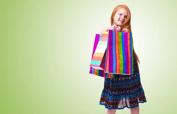 Compras infantiles. Moda feliz niña pelirroja con compras —  Fotos de Stock