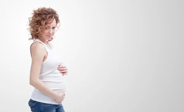 Zwangere vrouw op grijze achtergrond — Stockfoto