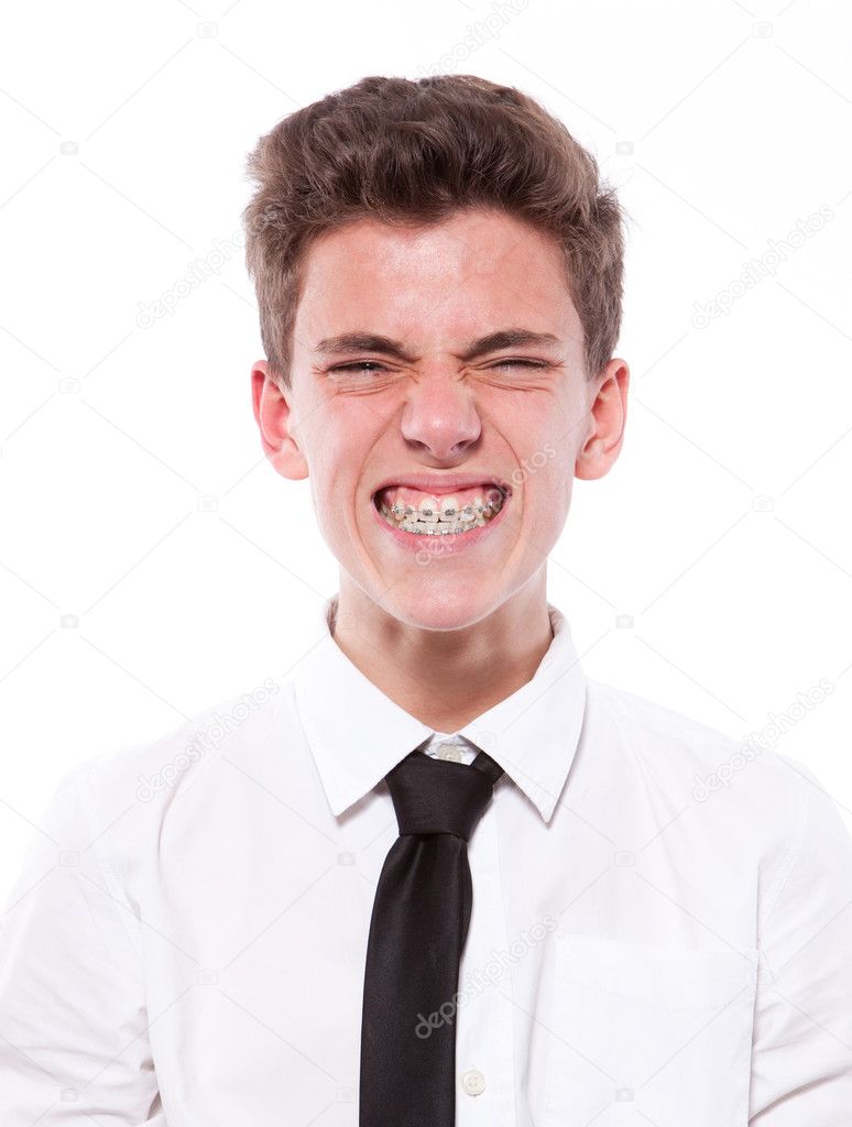 Grimace of teenage boy with braces. Isolated on white background