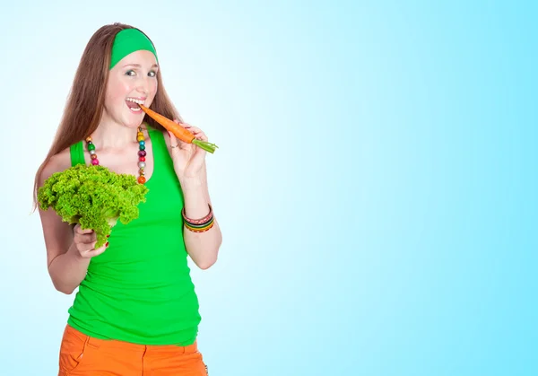 Portret van vrolijke vrouw wortelen, eten op blauwe achtergrond — Stockfoto