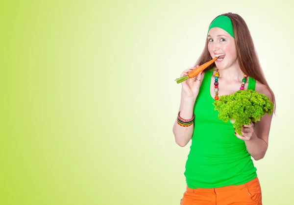 Portret van vrolijke vrouw eten wortelen, over groene pagina — Stockfoto