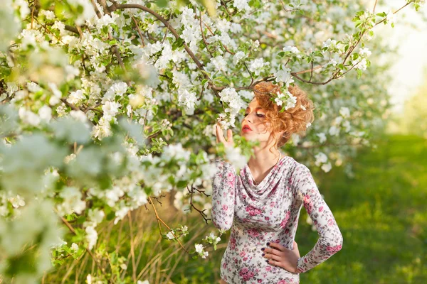 Vacker blondin i en våren trädgård — Stockfoto