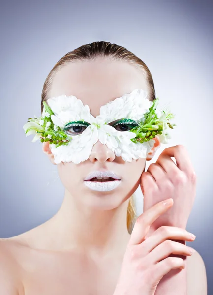 Mooie vrouw portret in masker uit de bloemen — Stockfoto