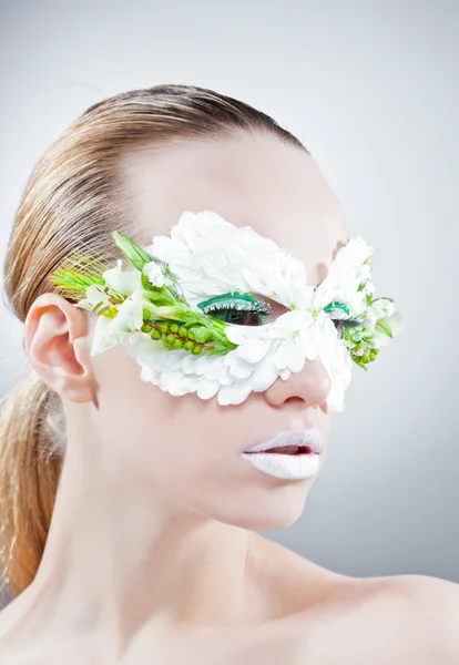 Mooie vrouw portret in masker uit de bloemen — Stockfoto