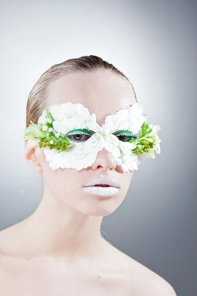 Mooie vrouw portret in masker uit de bloemen — Stockfoto