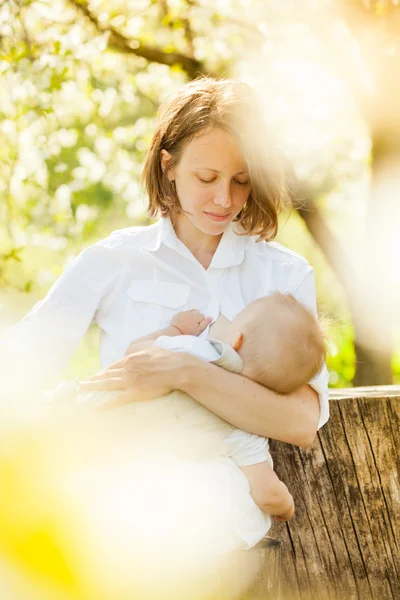 Moeder haar baby voeden met borst buiten schot — Stockfoto