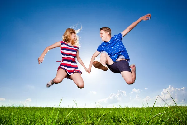 Fun couple in jump on the outdoor background Royalty Free Stock Photos