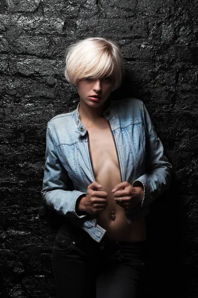 Страстная блондинка возле черной кирпичной стены — стоковое фото