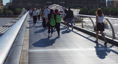 LONDON, UK - CIRCA SEPTEMBER 2019: Thames Nehri üzerindeki Milenyum Köprüsü 'ndeki insanlar Londra şehrini St Paul Katedrali ile Tate Modern sanat galerisi arasındaki Güney Bankası' na bağlıyor