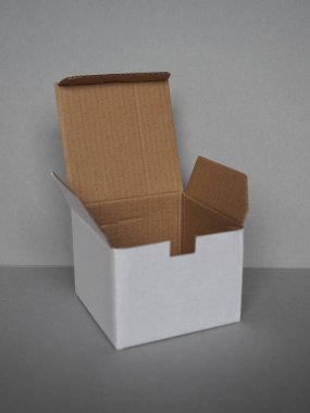 Gri duvarın önündeki boş karton kutu