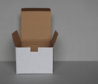 Gri duvarın önündeki boş karton kutu