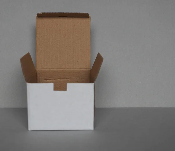 Prázdná Lepenková Krabice Před Šedou Stěnou — Stock fotografie