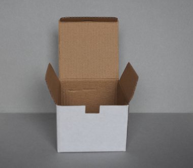 Gri duvarın önündeki boş karton kutu