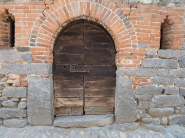 ancient medieval wooden door gate in stone and brick wall