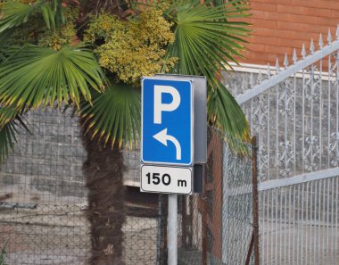 parking sign with direction arrow and distance