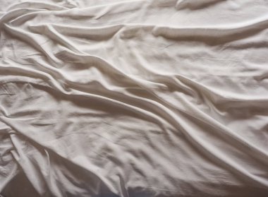 Yapılmamış bir yatakta endüstriyel beyaz pamuk çarşaflar