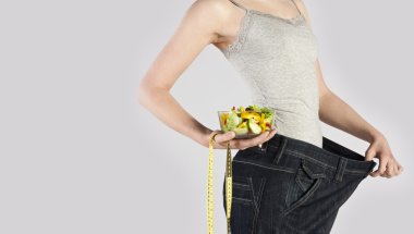 ince bir genç kız. gri arka plan üzerinde izole.