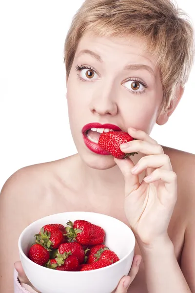 Junge Blondine mit rotem Lippenstift. Erdbeeren essen — Stockfoto