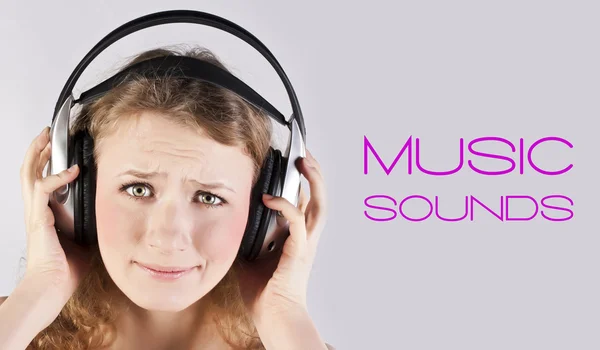 Blond lyssnar på musik i hörlurar — Stockfoto