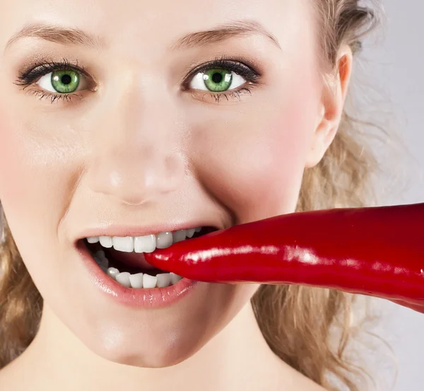 Bela mulher dentes comendo pimenta quente vermelha — Fotografia de Stock