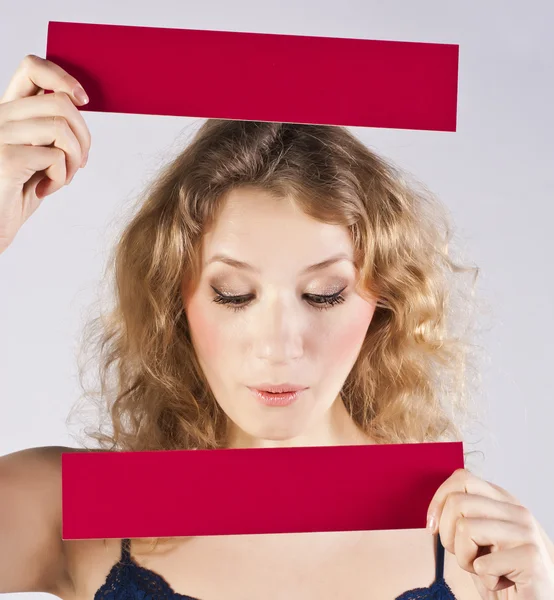 Woman holding a banner.Young beautiful curly blonde in studio — Stock Photo, Image