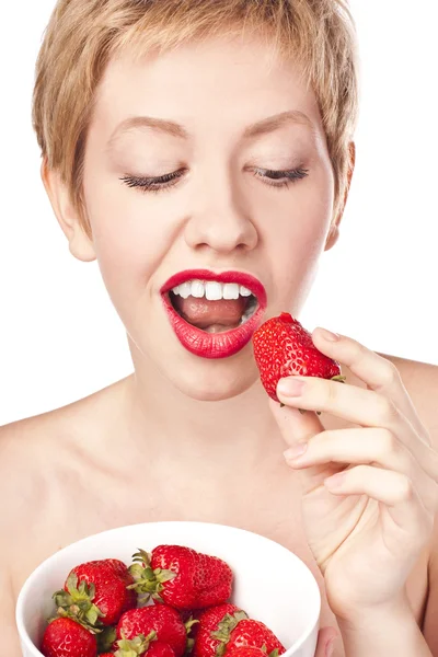 Young blonde with red lipstick. Eating strawberries Stock Picture