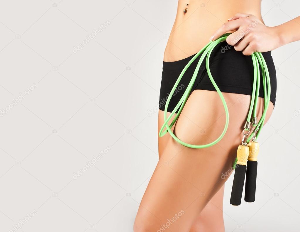 Nice sporty women body. Holding rope
