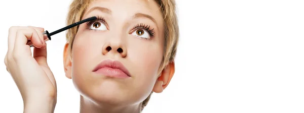 Young woman paints the eyelashes — Stock Photo, Image