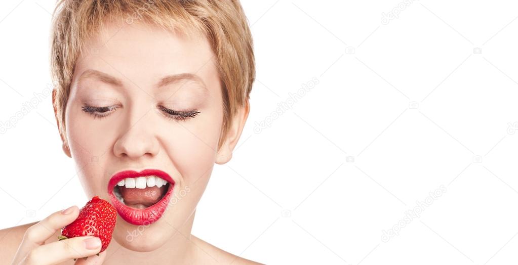 Young blonde with red lipstick. Eating strawberries Stock Photo by