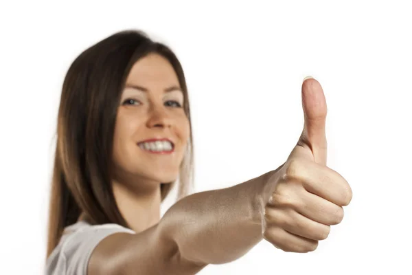 Счастливая улыбающаяся женщина в белой футболке показывает большие пальцы вверх — стоковое фото