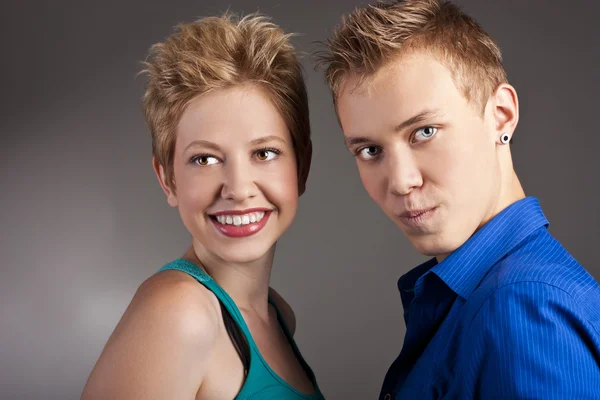 Cheerful young couple standing in studio — Stock Photo, Image