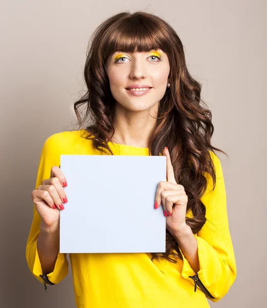 Giovane donna in studio tenendo cartello — Foto Stock