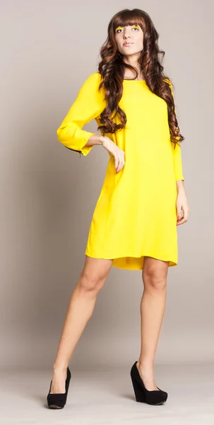 Belle jeune femme portant une robe jaune — Photo