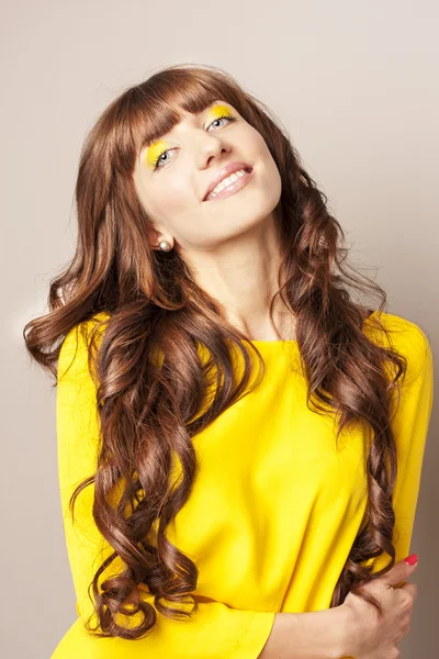Mujer en amarillo con cabello lujoso — Foto de Stock