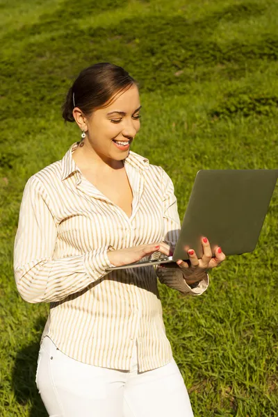 Fiatal nő, laptop, a zöld fű — Stock Fotó
