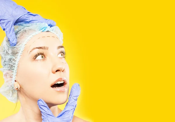 Лікар маркує жінку обличчям до пластичної хірургії — стокове фото