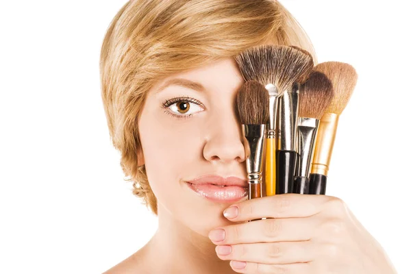 Vacker kvinna med make-up penslar nära attraktiva ansikte — Stockfoto