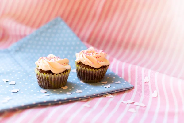 Cupcakes bonitos em uma toalha de mesa de bolinhas — Fotografia de Stock