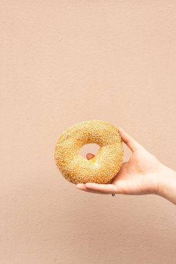 Bej arkaplanda susamlı yuvarlak simit.