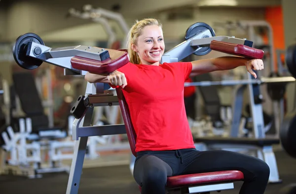 Joyeux jeune femme travaillant sur la machine d'exercice — Photo