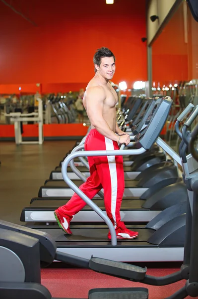 Joven musculoso haciendo ejercicio en una cinta de correr — Foto de Stock