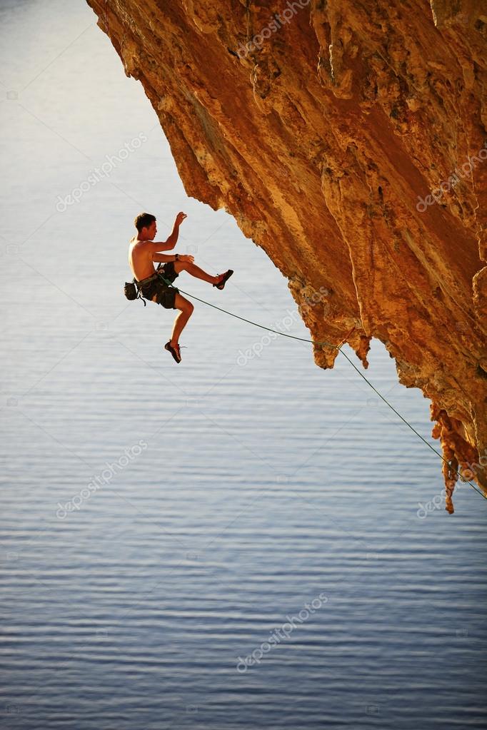 Rock climber falling of a cliff while lead climbing Stock Photo by