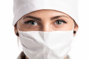 maske ve bir şapka giyen genç kadın doktor closeup